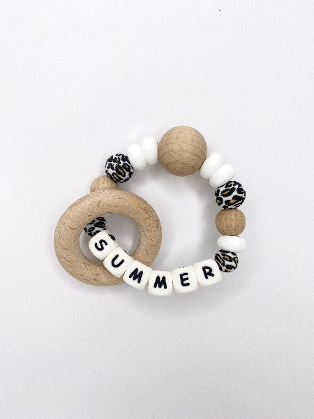 Teething rattle with animal print, white and wood beads with a personalised name in white beads with letters on them