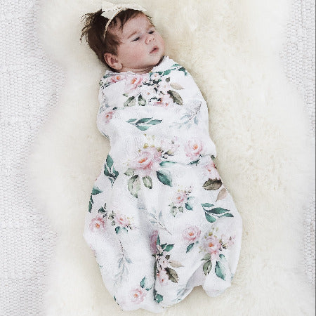 Baby wrapped in floral wrap with headband