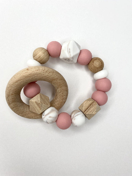 teething ring with pink, white marble and wood beads plus a small wooden ring around the main ring
